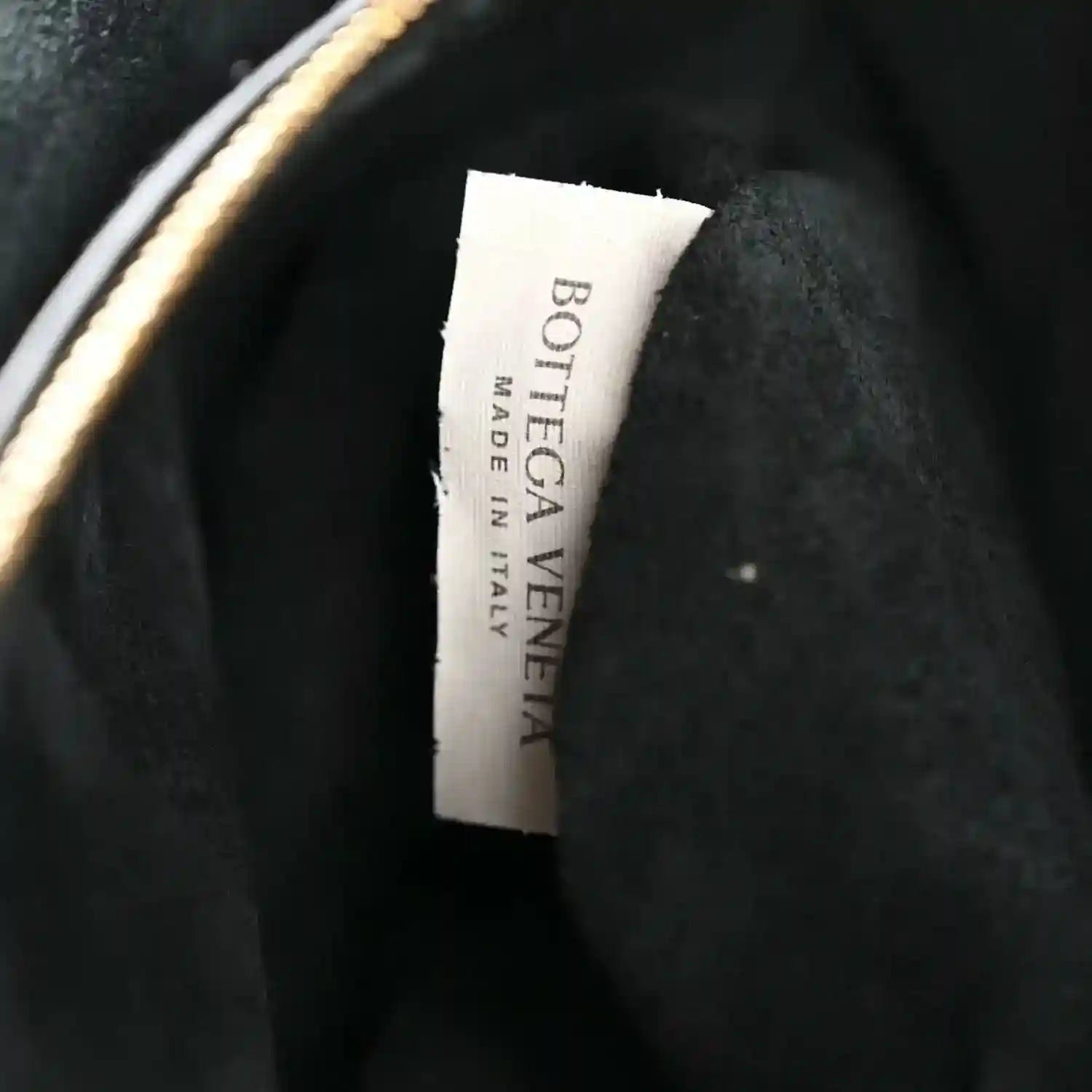 Black leather handbag with Bottega Veneta label on the inner lining.