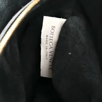 Black leather handbag with Bottega Veneta label on the inner lining.