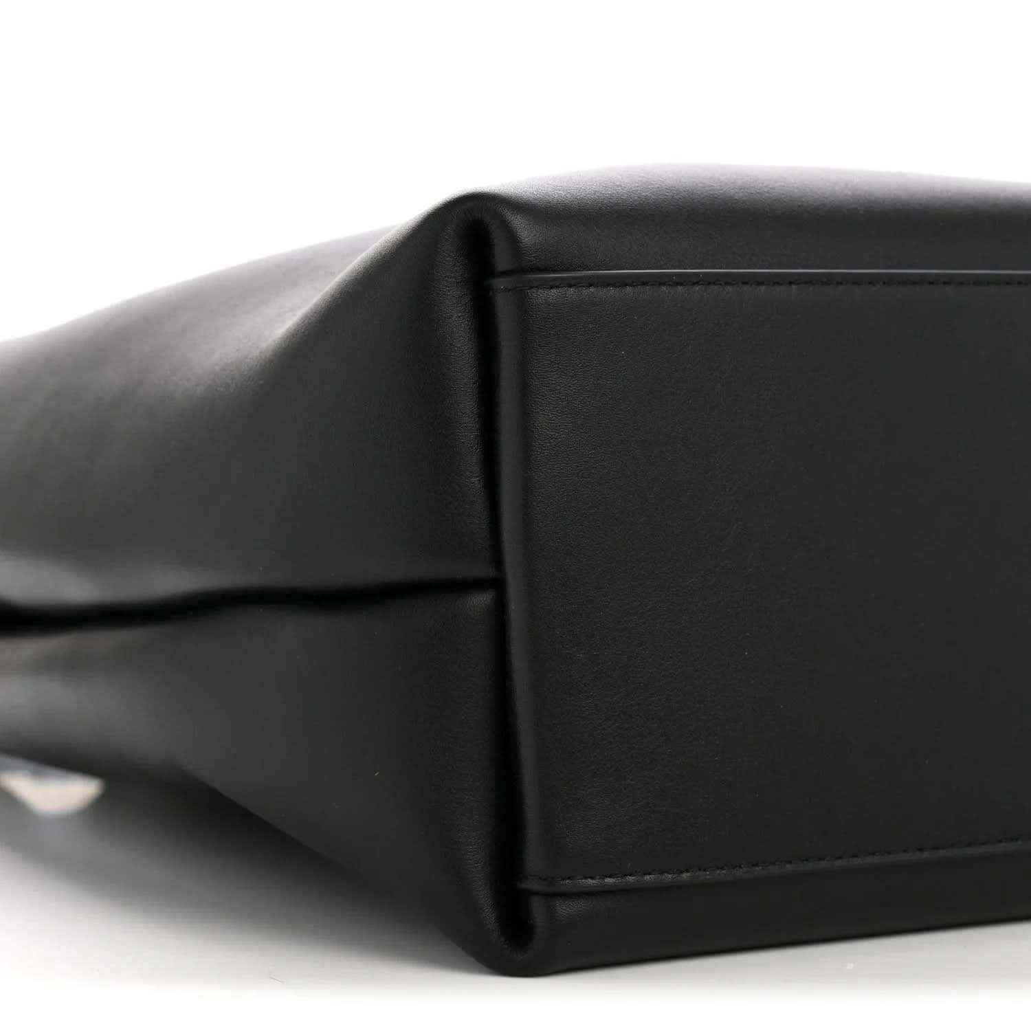 Black bucket bag side panel with seam detail and smooth leather texture