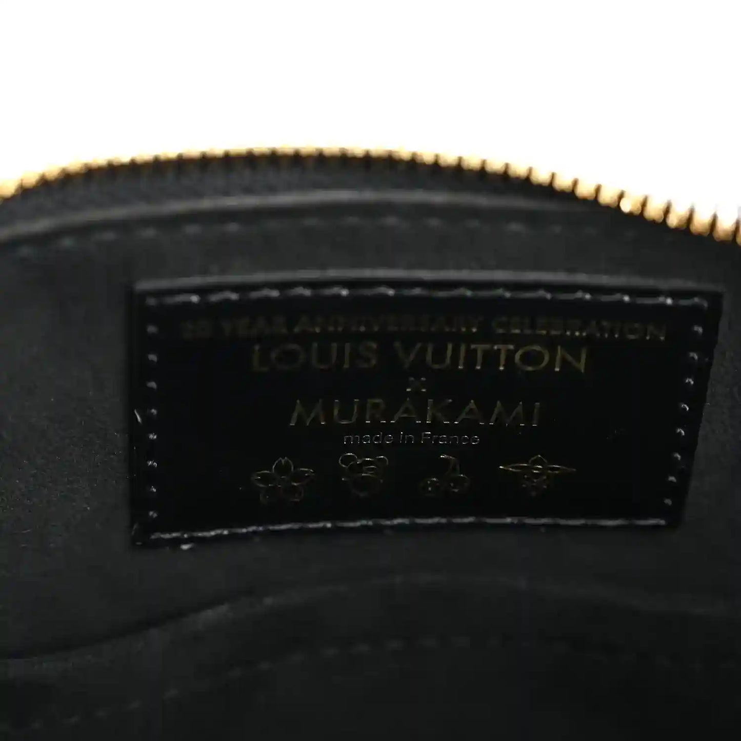 Louis Vuitton leather label inside black handbag with gold-toned zipper edge