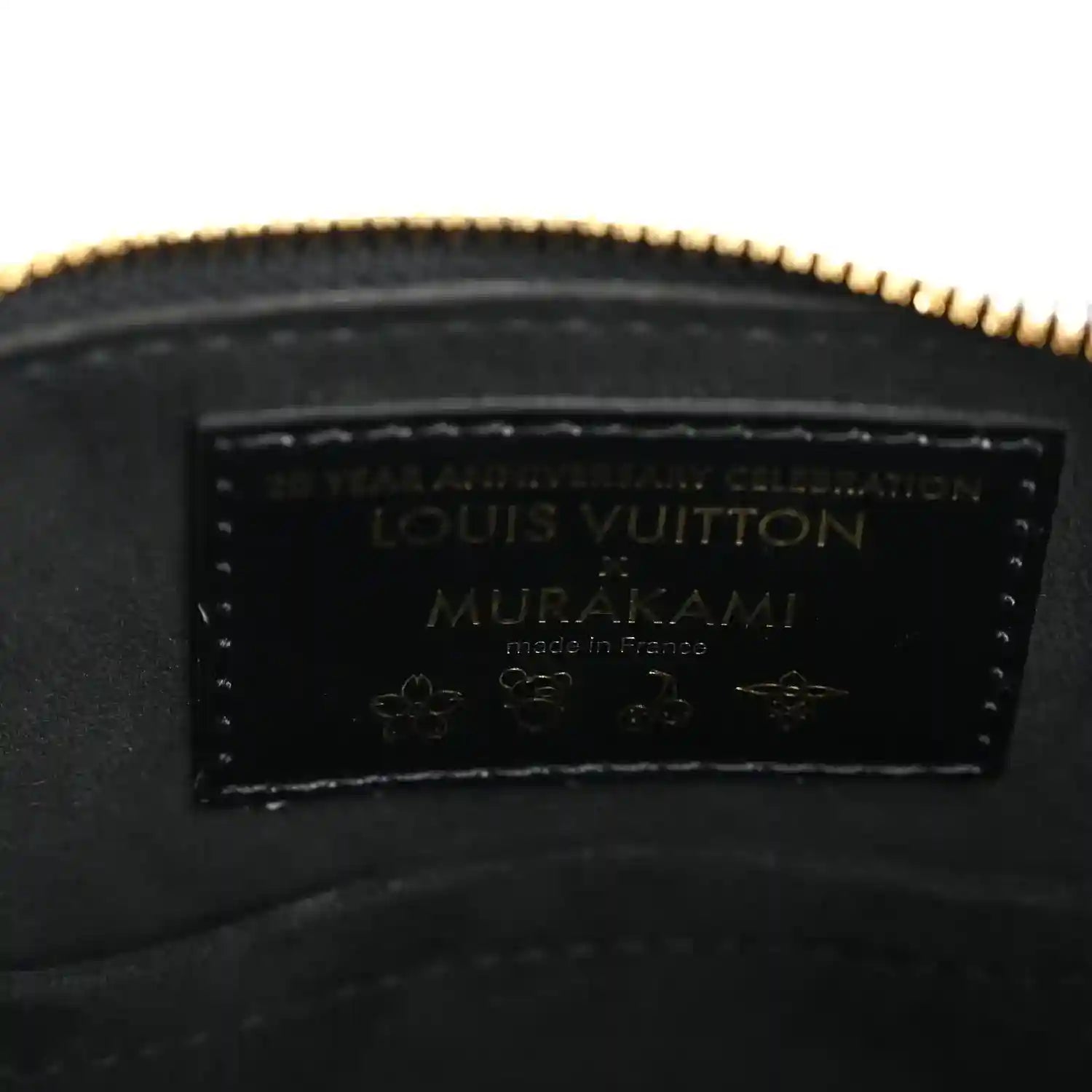 Louis Vuitton leather label inside black handbag with gold-toned zipper edge