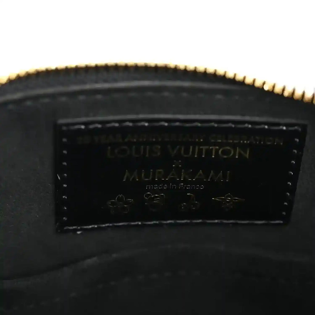 Louis Vuitton leather label inside black handbag with gold-toned zipper edge
