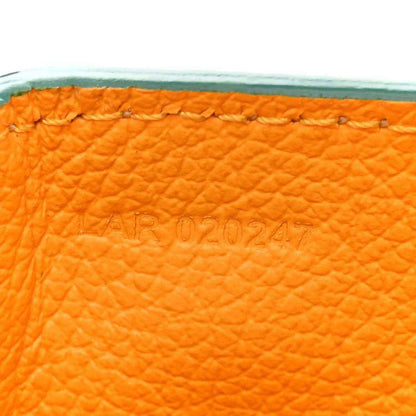 Embossed marking on orange lining inside the green mini bag