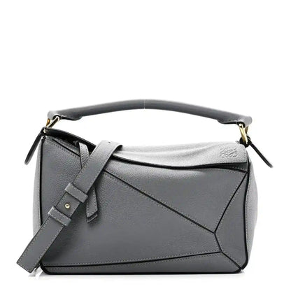 Small puzzle bag in dark gray soft grained leather with top handle and shoulder strap