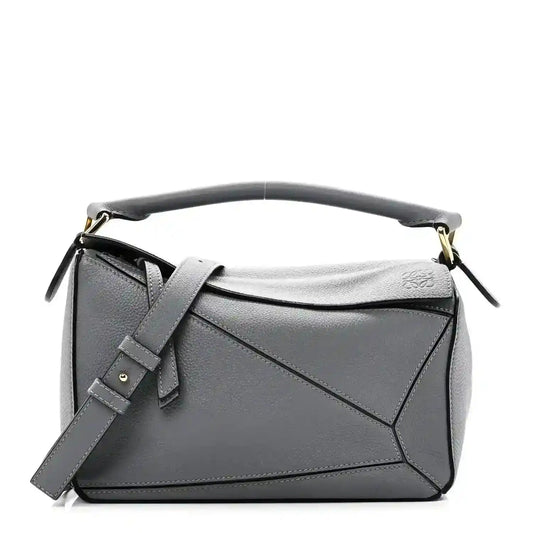Small puzzle bag in dark gray soft grained leather with top handle and shoulder strap