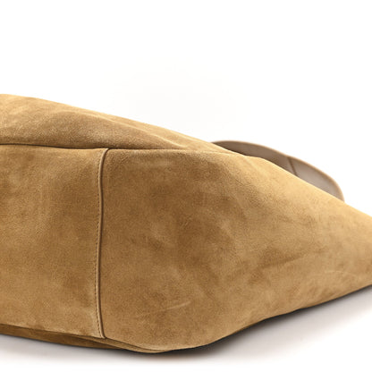 Suede tote bag side panel with curved base seam, golden-brown suede