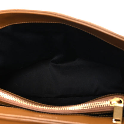 Satchel interior opening with gold zipper track and brown leather trim