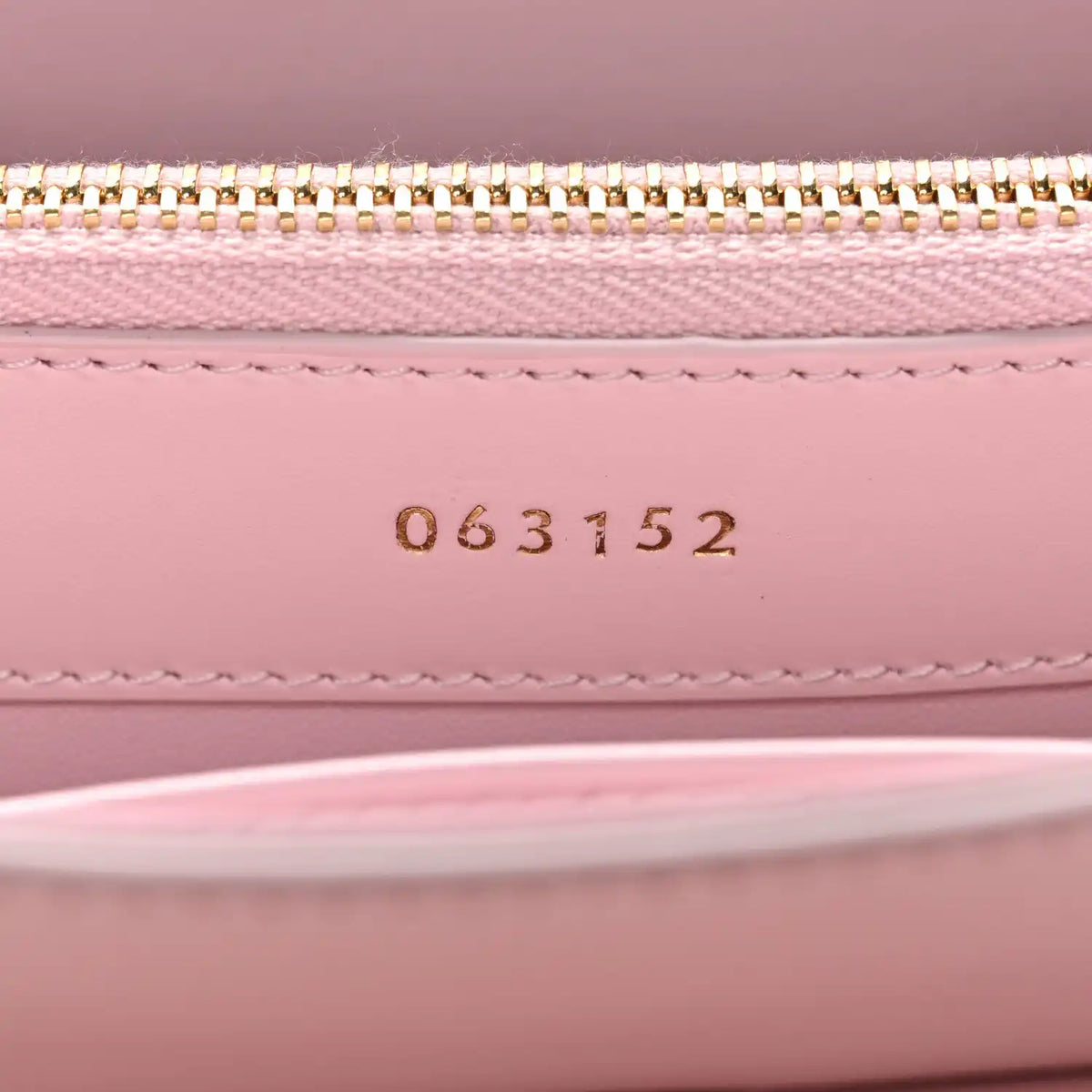Pastel pink mini bag interior with gold zipper and stamped code 063152