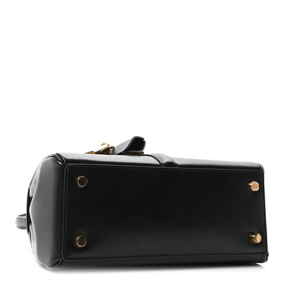 Celine mini top-handle bag side view in black leather with gold hardware snaps