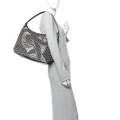 Goyard hobo bag shown in side view with black coated canvas and curved top handle
