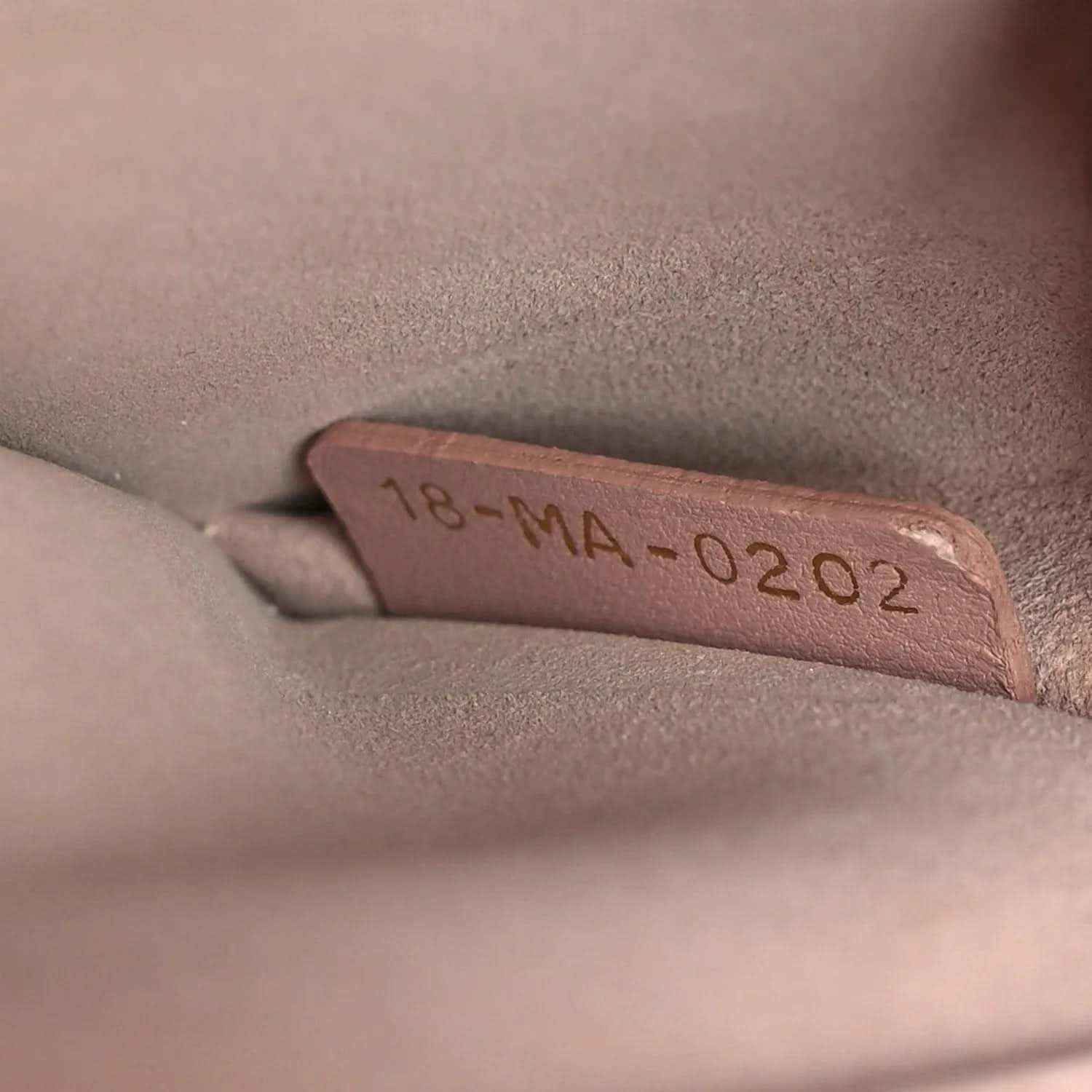 Lambskin handbag interior stamp reading 18-MA-02 2022 on pale pink lining
