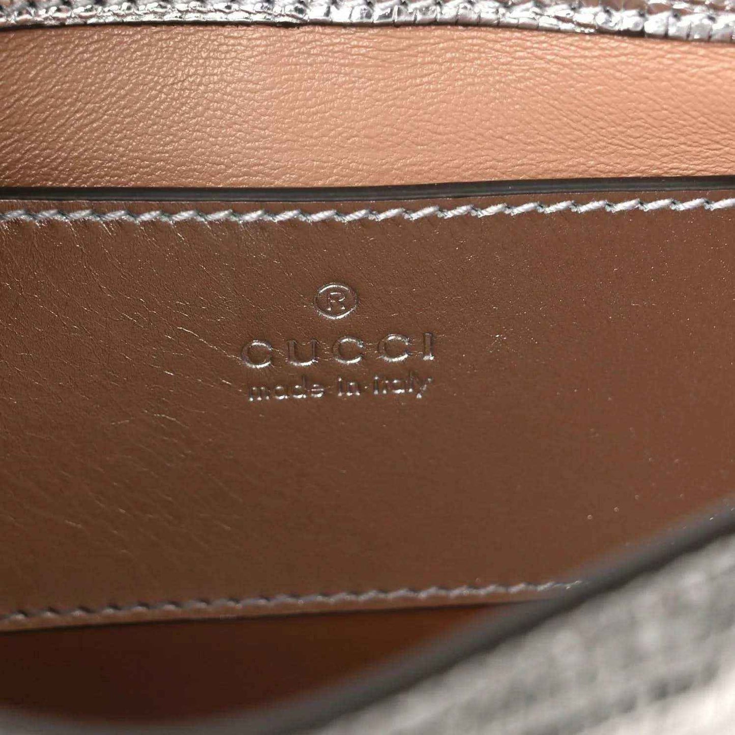 Gucci stamped leather interior panel with stitched edge