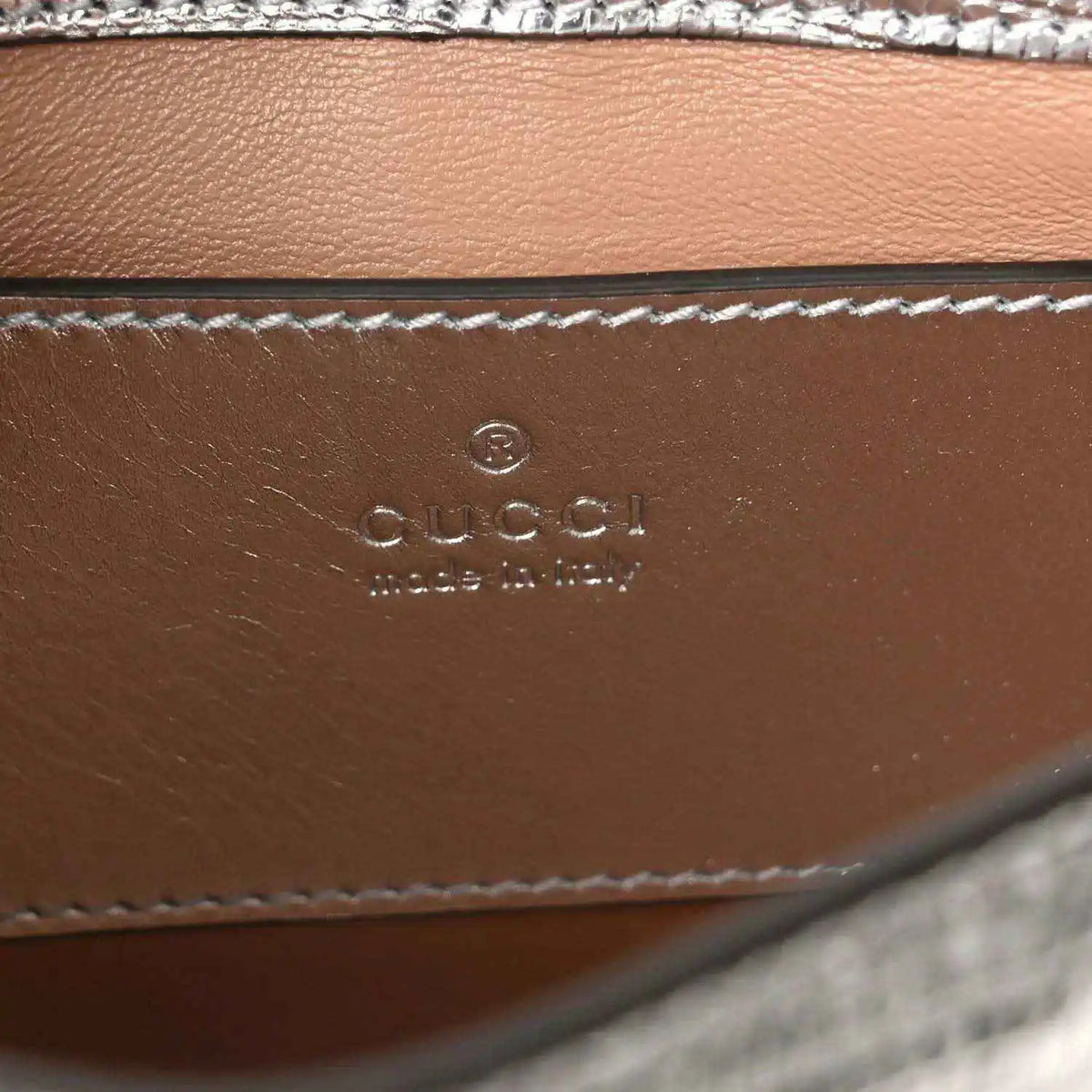 Gucci stamped leather interior panel with stitched edge