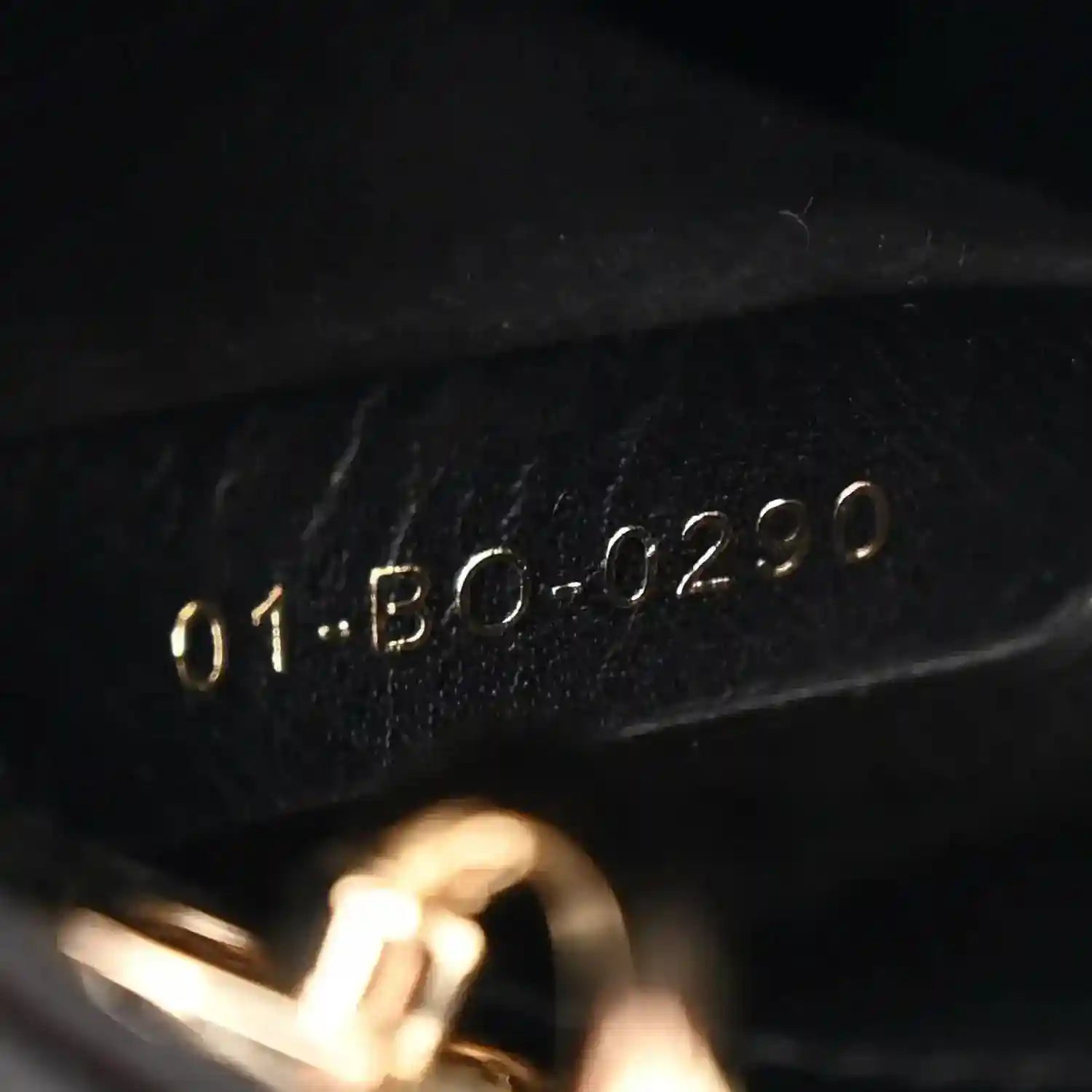 Black leather handbag interior serial stamp with gold-tone numbers
