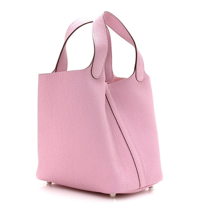 Rose pink leather handbag with structured sides, top handles, and lock clasp