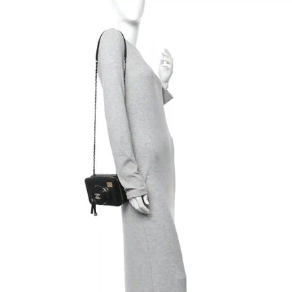 Black quilted lambskin crossbody bag with chain strap and small top flap on arm