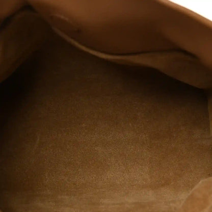 Tan leather mini clutch interior close-up with smooth fabric lining.