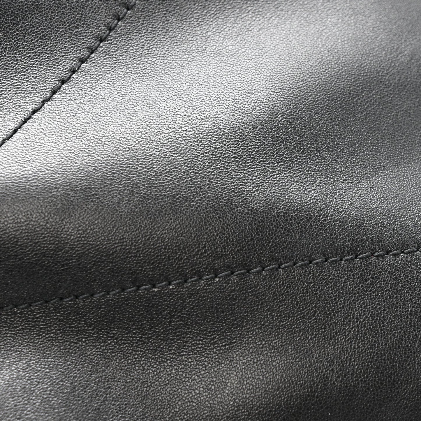 Black leather bag panel with fine grain texture and contrast stitching