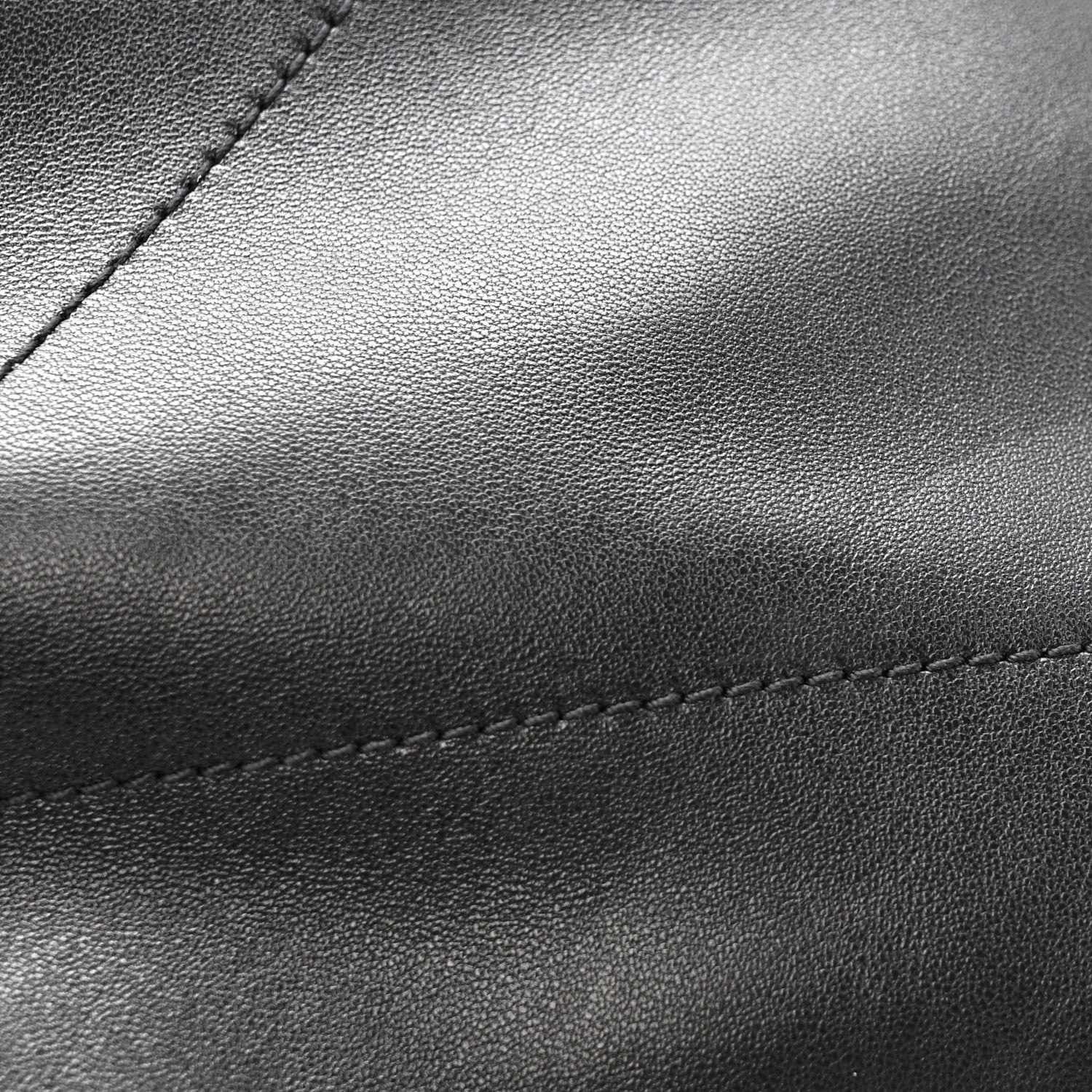 Black leather bag panel with fine grain texture and contrast stitching