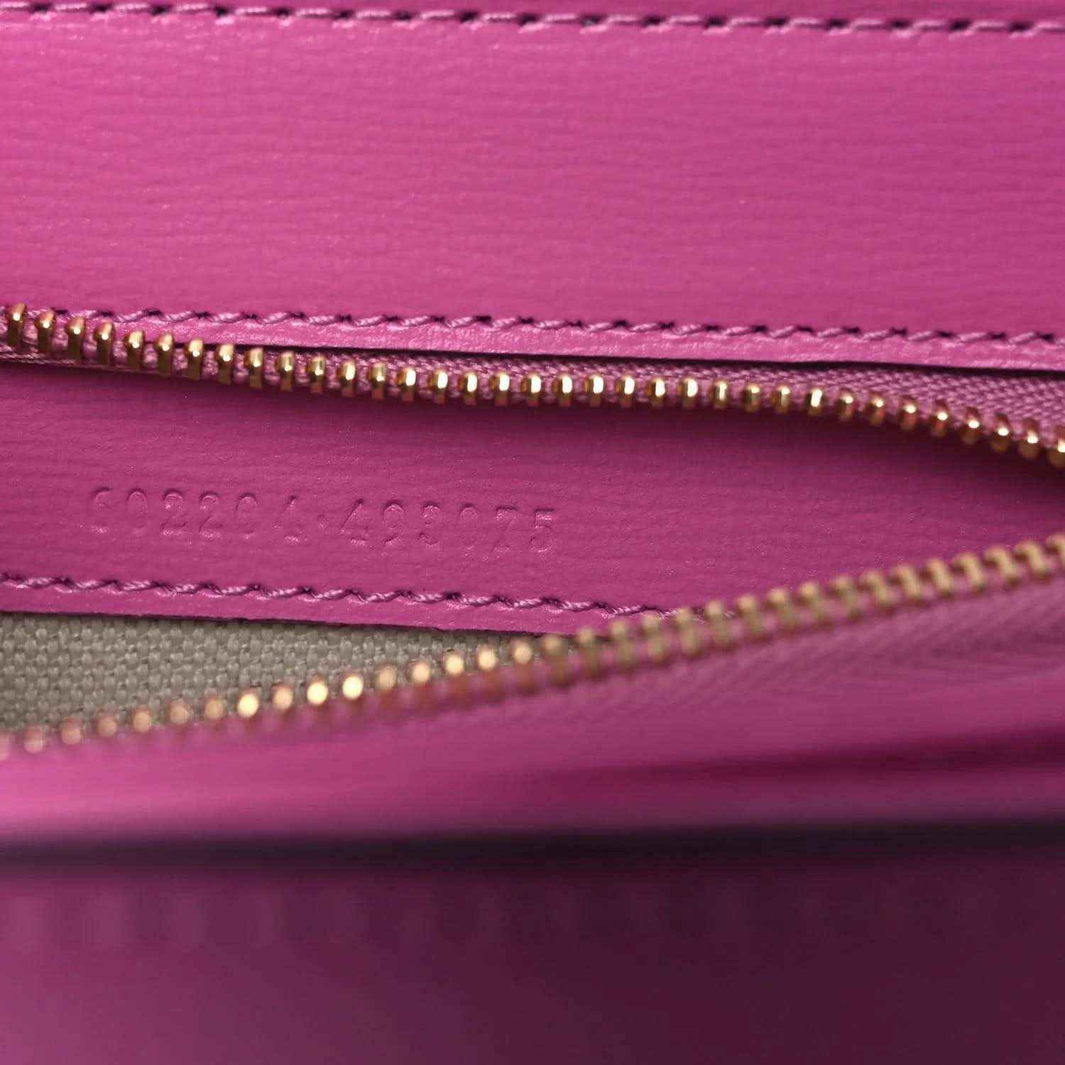 Gucci pink bag interior close-up of gold zipper and stitched inner pocket