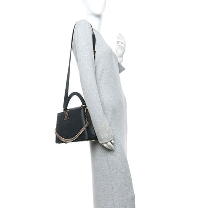 Black leather handbag with top handle, gold chain strap, and small LV emblem