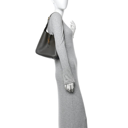 Calfskin hobo bag with top handle, carried over a sleeve on a mannequin.