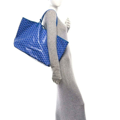 Sky blue Goyardine tote bag with open top, blue handles, and light fabric lining.
