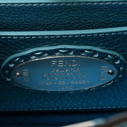 Blue leather satchel tag with Fendi logo and serial text on front hardware.