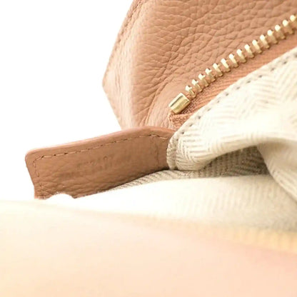 Toffee leather zipper edge with gold hardware and textured lining