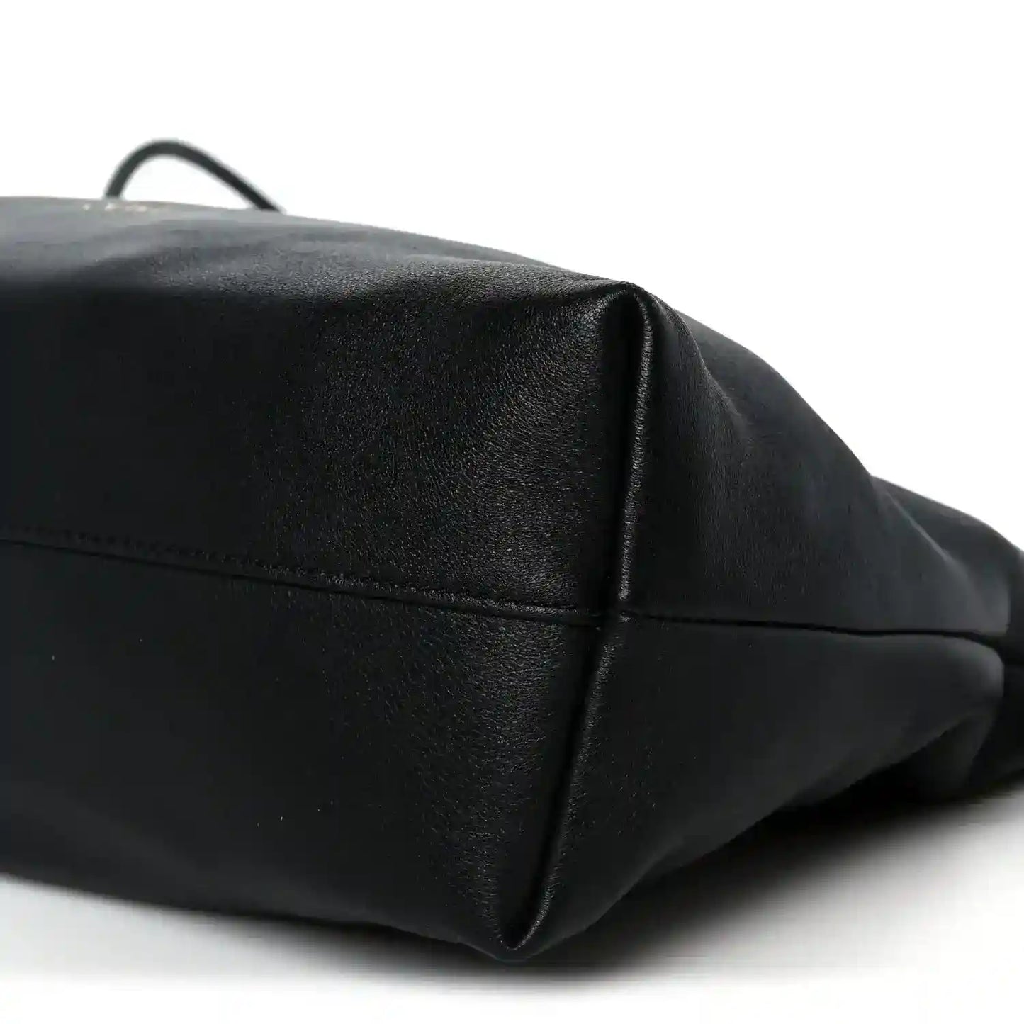 Black leather clutch corner view with top edge seam and subtle pebbled texture.