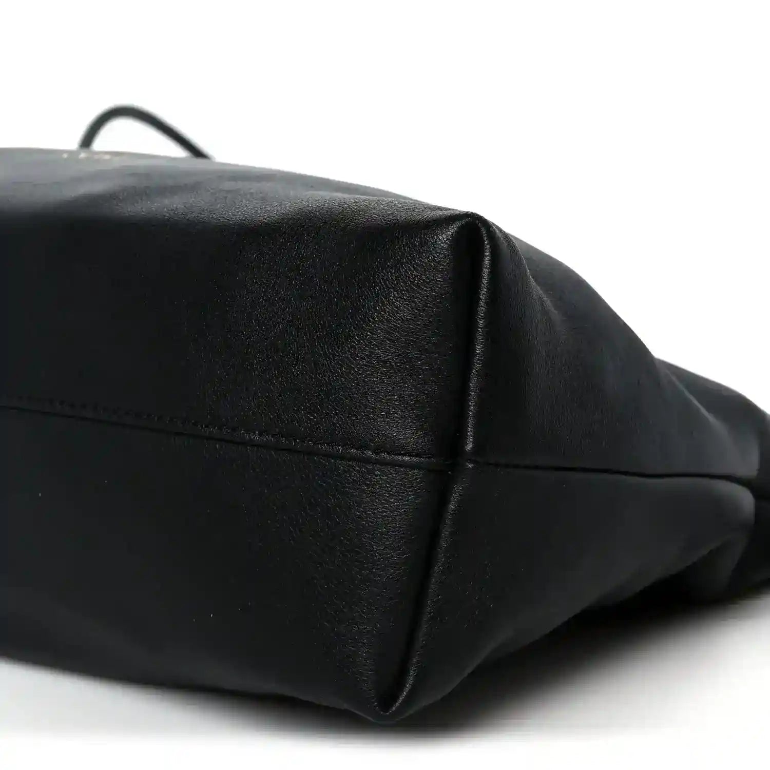 Black leather clutch corner view with top edge seam and subtle pebbled texture.