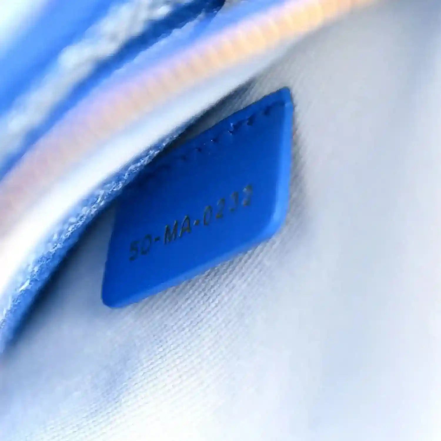 Blue leather interior stamp tab with embossed text 'Made in Italy'