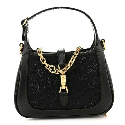 Black hobo bag with top handle, gold chain detail, and leather clasp accent.