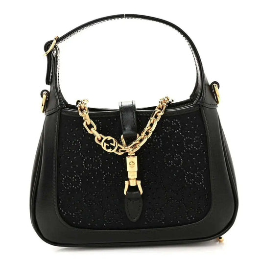 Black hobo bag with top handle, gold chain detail, and leather clasp accent.
