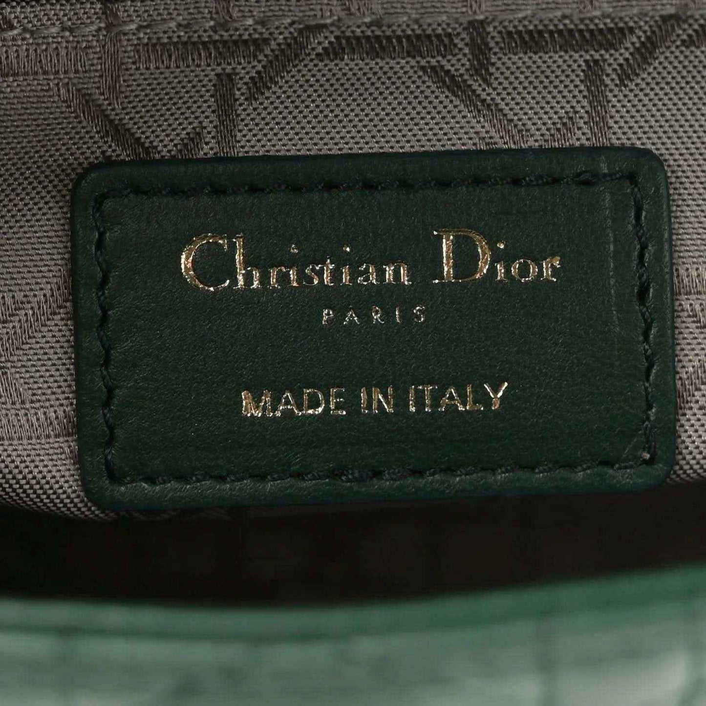 Green leather logo patch reading Christian Dior Paris, made in Italy