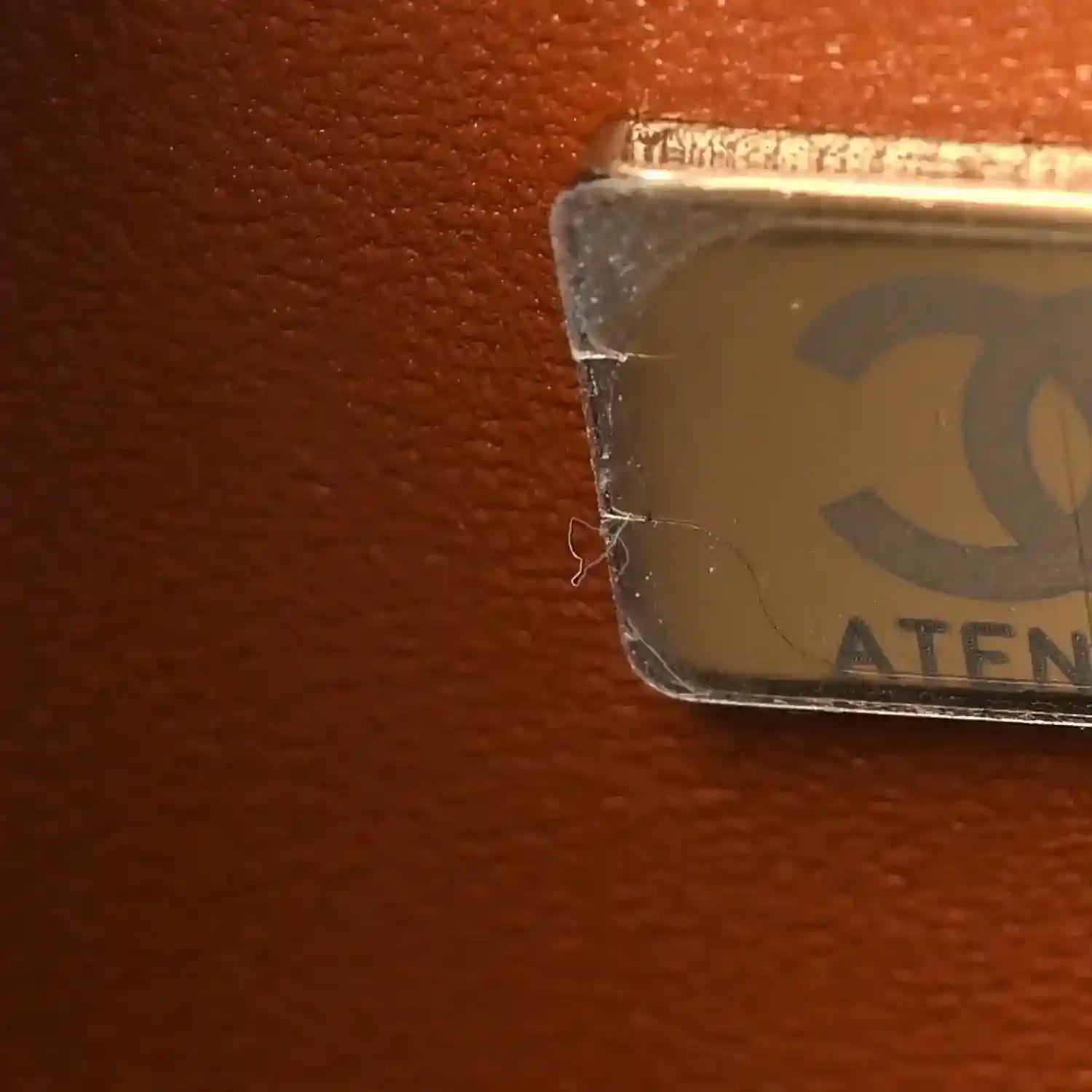 Caramel leather bag corner with protective label covering the edge