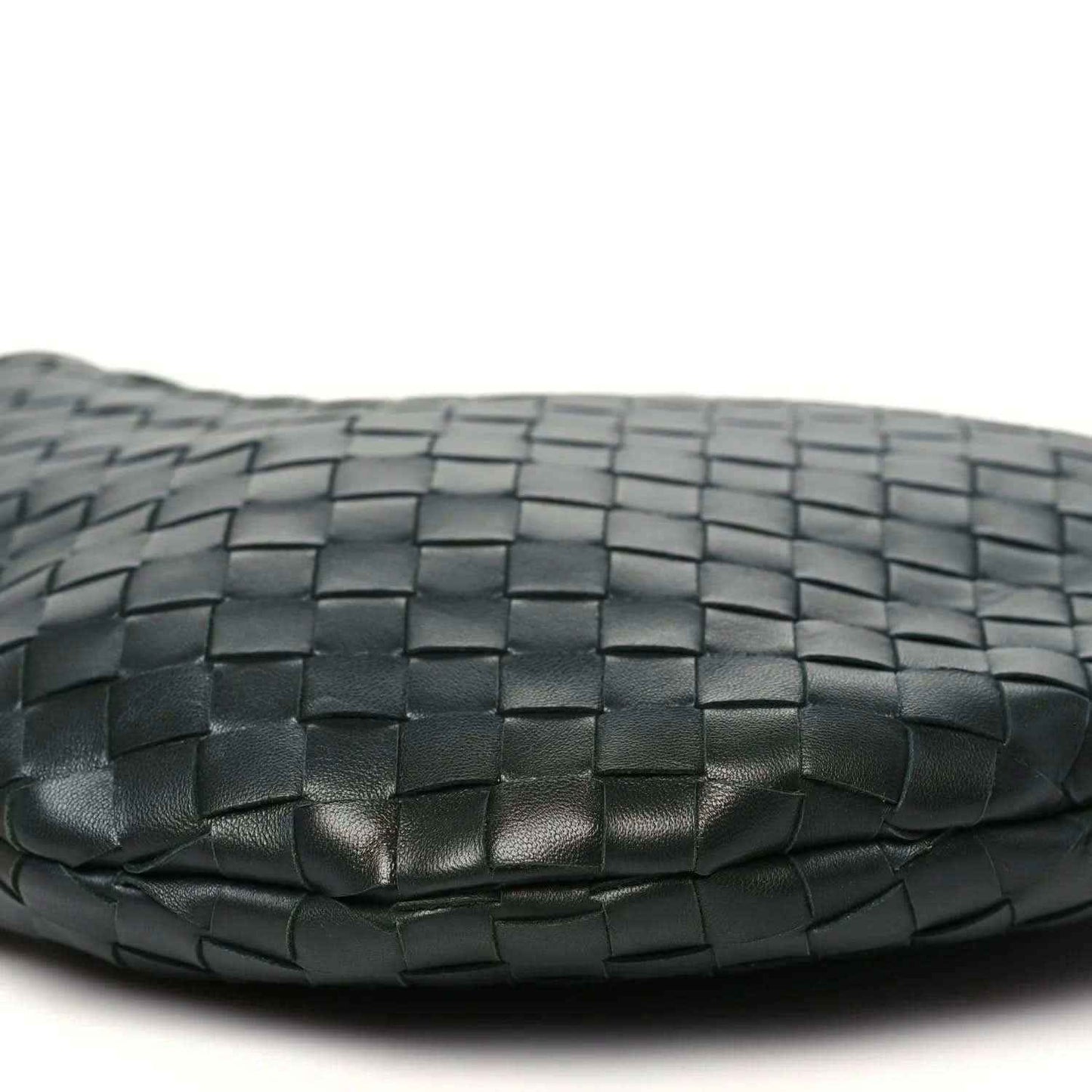Close-up of dark green woven leather base with subtle creases