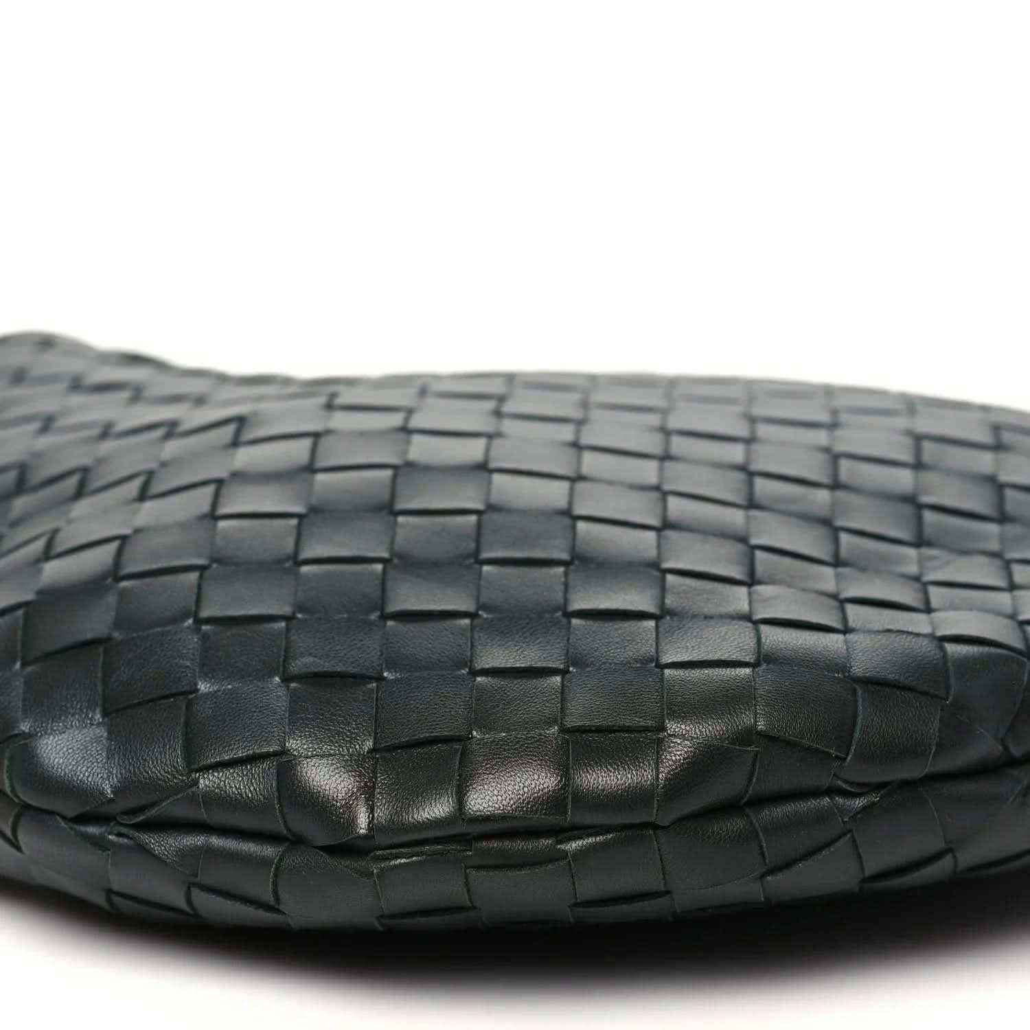 Close-up of dark green woven leather base with subtle creases