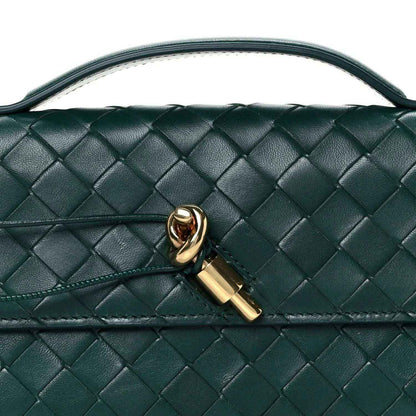 Emerald green intrecciato nappa clutch bag close-up with gold clasp detail