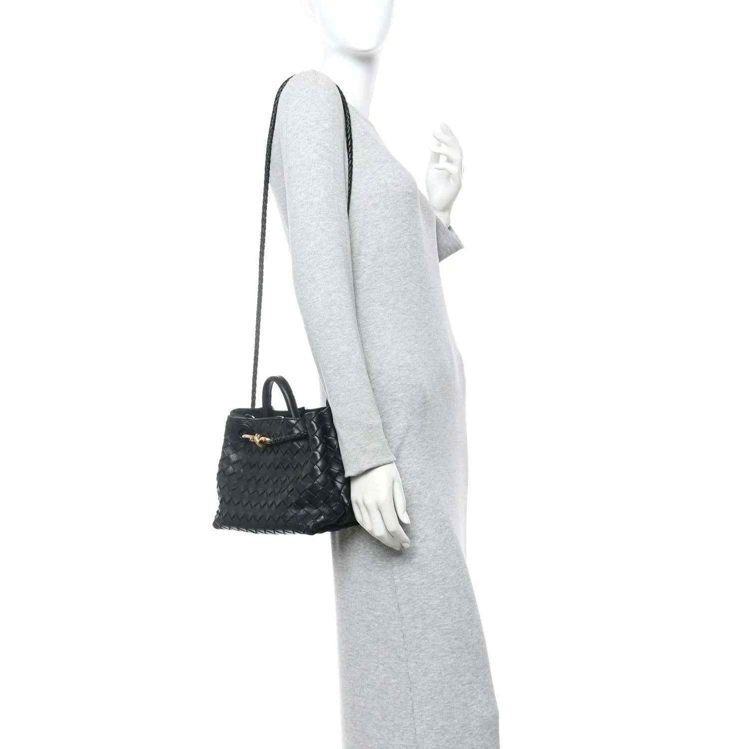 Black woven leather mini shoulder bag worn with a thin crossbody strap