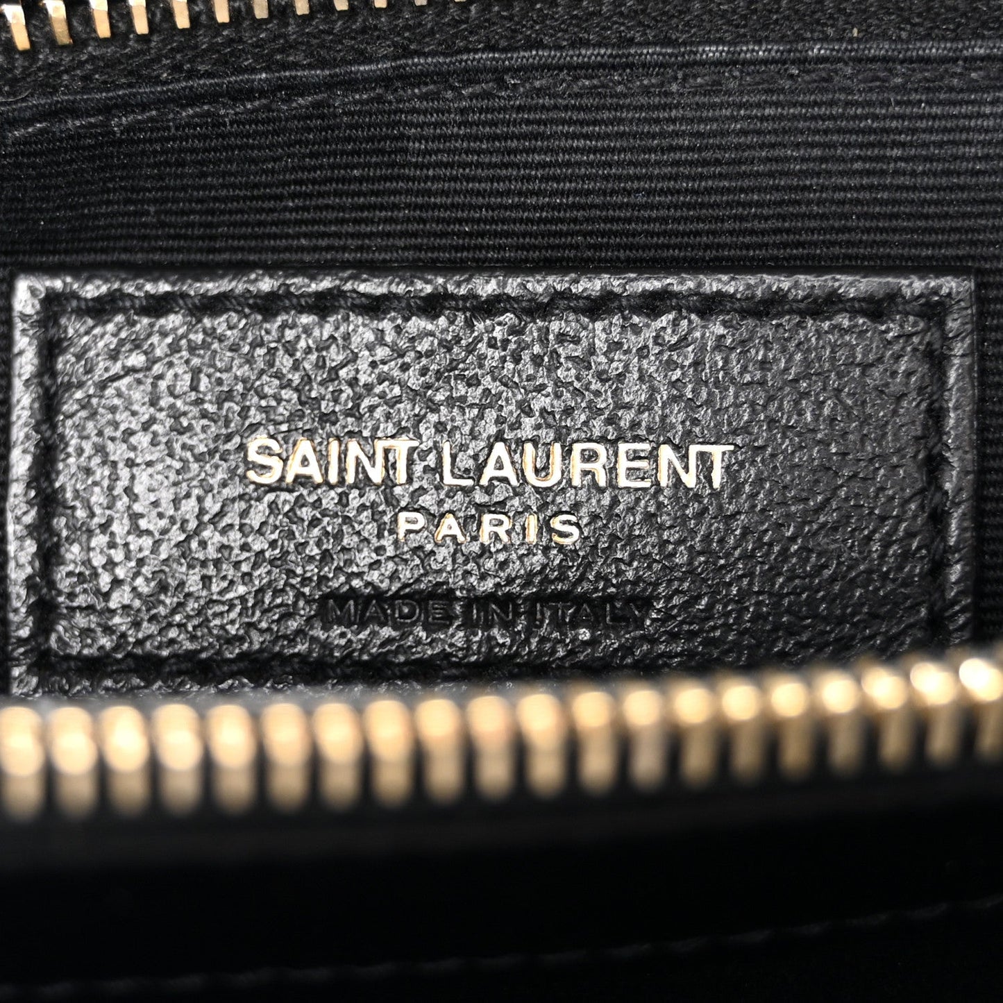 Black satchel interior leather label reading SAINT LAURENT PARIS, gold zipper edge