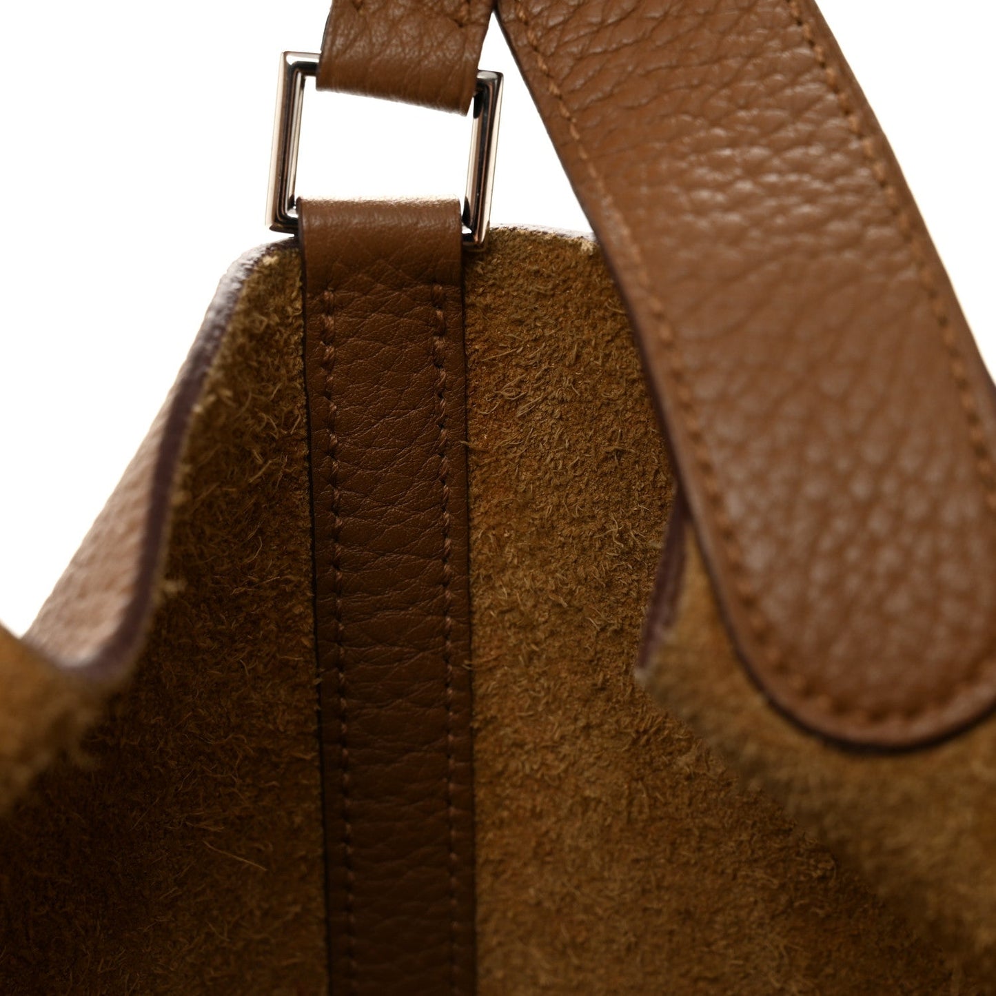 Tan leather tote strap with metal buckle hardware, textured grain