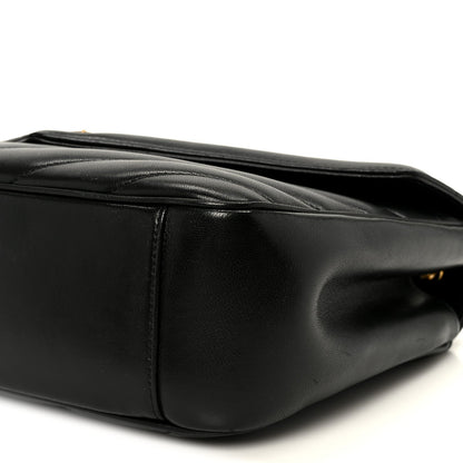 Black leather shoulder bag side with stitched trim and rounded base
