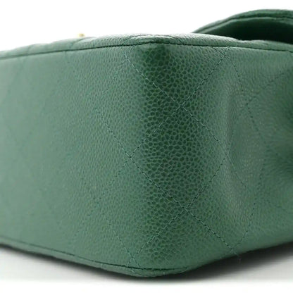 Green quilted caviar leather bag side with stitched diamond quilting pattern.
