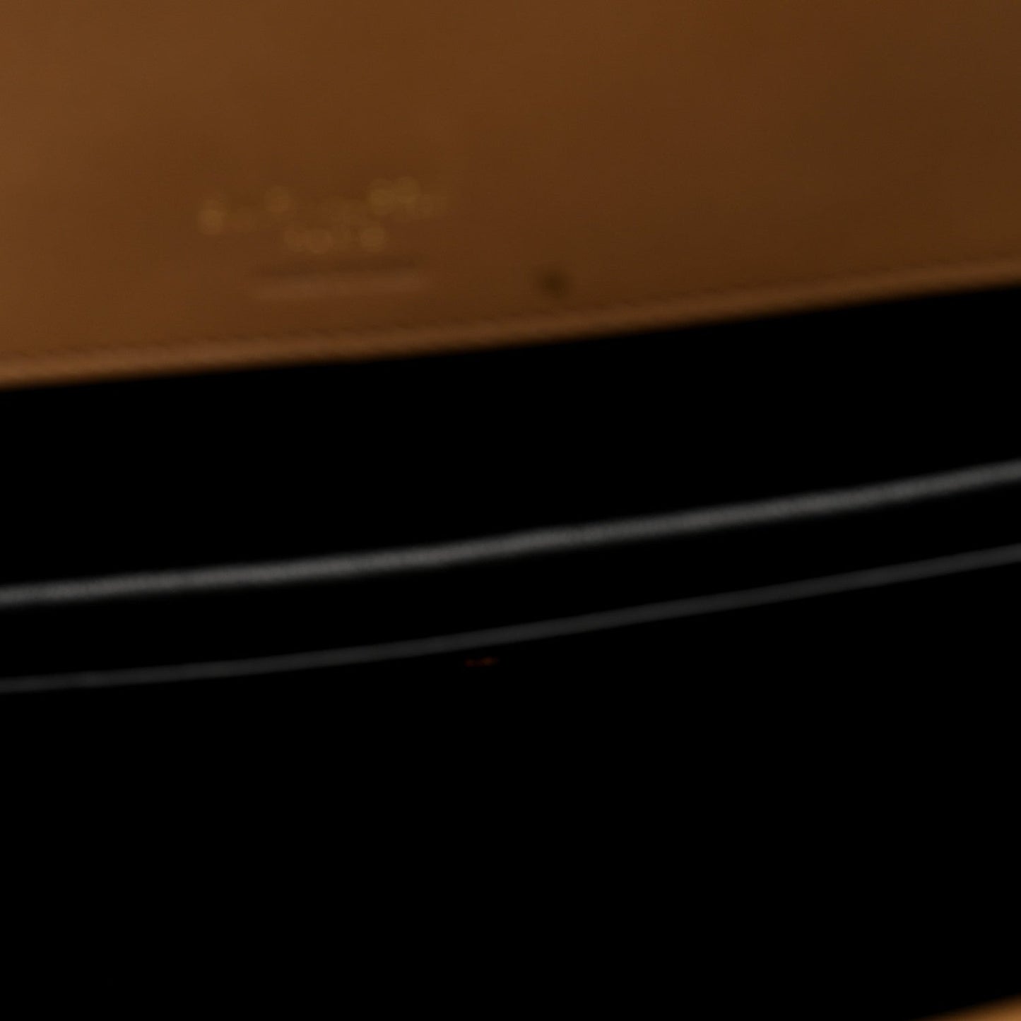 Close-up showing dark interior area with natural tan leather trim