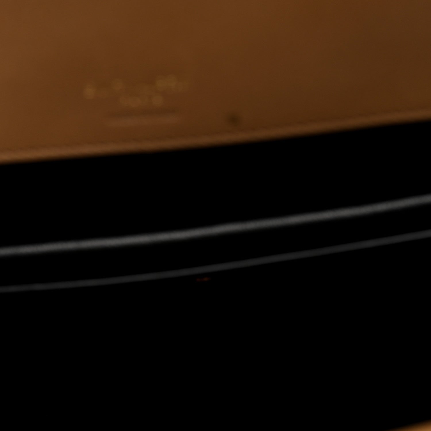 Close-up showing dark interior area with natural tan leather trim