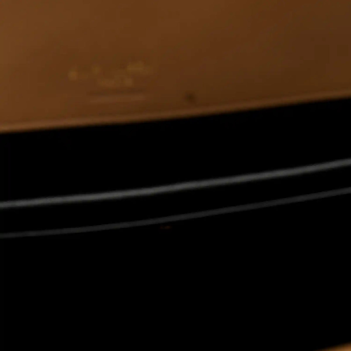 Close-up showing dark interior area with natural tan leather trim