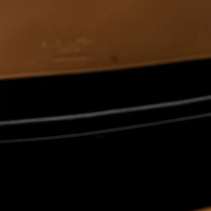 Close-up showing dark interior area with natural tan leather trim