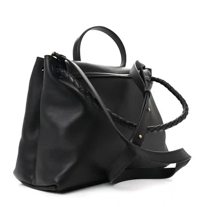 Black leather shoulder bag with braided strap, flap front, and gold hardware studs.