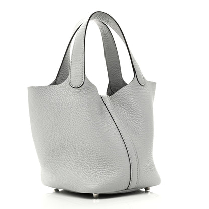 Light blue pebbled leather tote bag with curved side panel and top handles